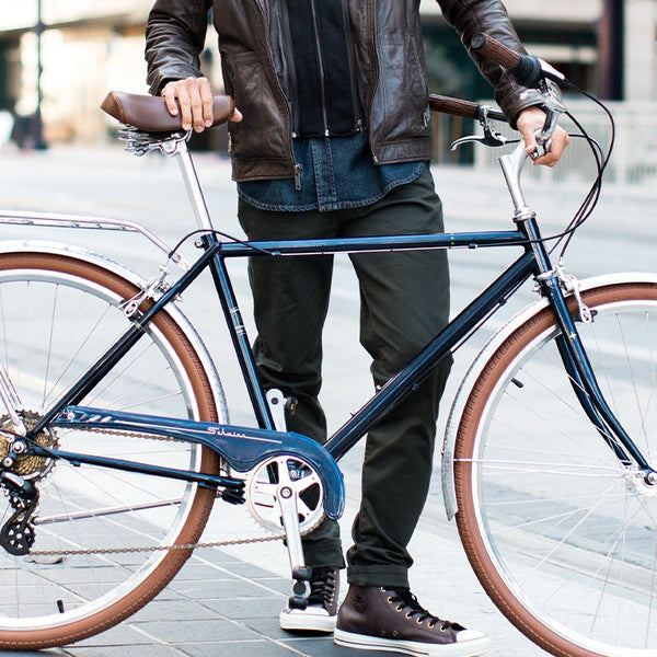 A person standing with their Schwinn Traveler hybrid bike.