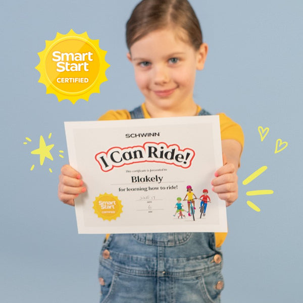 Blakely holding up her 'I Can Ride' SmartStart certificate.